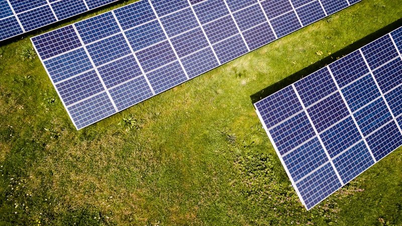 Aerial view of solar panels installed across a green field